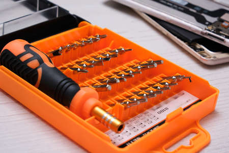 mini set of bits for a screwdriver in an orange box, a set for repairing a telephone and a broken...