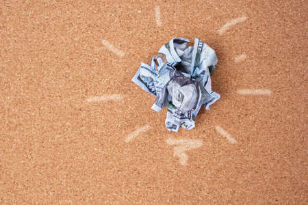 Concept idea of saving money. crumpled 100 dollar bill on cork board backgroundの写真素材