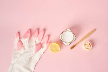 rubber gloves, loofah, soda, brush and lemon on pink background, cleaning with non-toxic detergents,...