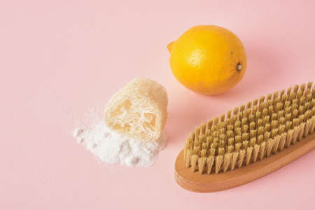 soda spilled, loofah, lemon and wooden cleaning brush on pink backgroundの写真素材