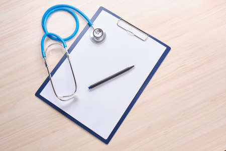 pills, stethoscope and note pad on the wooden tableの写真素材