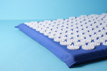 Acupuncture massage mat on blue background copy spaceの写真素材