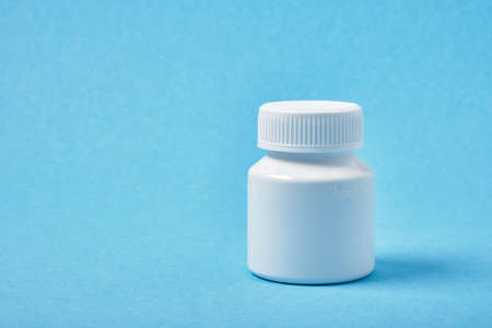 medicine white pill bottle on a blue background copy spaceの写真素材