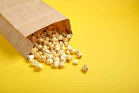 popcorm paper bag on yellow background copy spaceの写真素材
