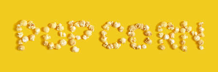 Inscription popcorn on a yellow background close-up, top viewの写真素材