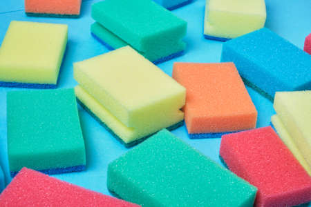 New colorful sponges for washing dishes on a blue background