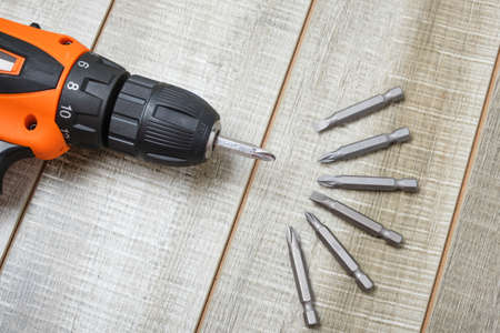 electric screwdriver, self-tapping screws, screwdriver bits, tool box on a wooden background copy spaceの写真素材