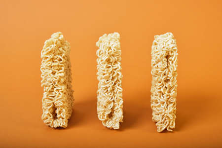 three standing block dry instant noodles on brown backgroundの写真素材