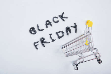 inscription black friday from plasticine and mini shopping trolley on gray background top viewの写真素材