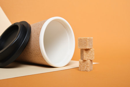 brown sugar cubes and thermo mug made of cork on a beige and brown background copy spaceの写真素材