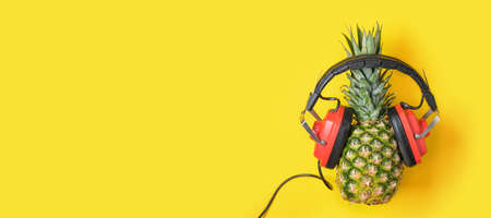pineapple in red retro headphones on yellow background, music lover concept copy spaceの写真素材