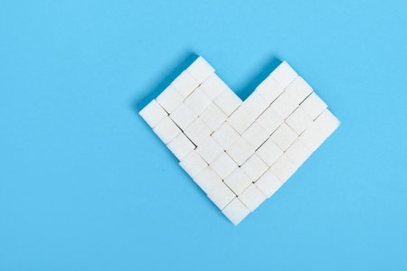 heart made of sugar cubes on a blue background copy space top viewの写真素材