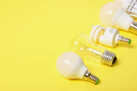 several different bulbs on a yellow background, copy space, trend color, broken and burned out bulbs...