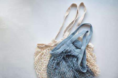 two knitted mesh eco shopping bags on a light background, natural thread shoppers, eco friendly...