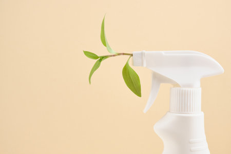 Spray bottle with leaf spray for eco friendly natural cleaning concepts. on beige background copy...