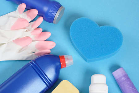 Colorful cleaning set for different surfaces in kitchen, bathroom Cleaning service and spring cleaning concept. copy space blue background sponge, gloves and detergent bottlesの写真素材