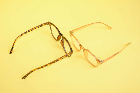 a lot of trendy trendy eyes glasses for vision correction on a yellow background copy spaceの写真素材