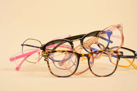 pile of fashionable trendy eyes glasses for correcting vision on a colorful background, a geometric...