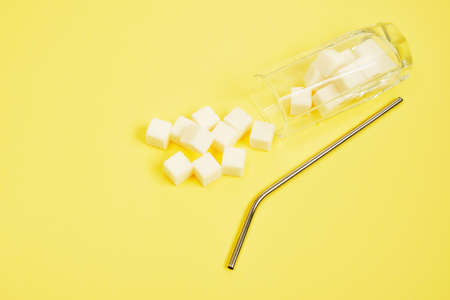 cocktail tube and sugar cubes in a glass on blue and yellow background copy space Too much sugar in drinks conceptの写真素材