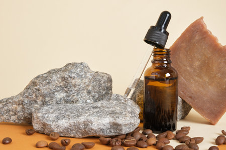 brown bottle for cosmetics with pipette and cocao handmade soap on beige background, scattered coffee beans, stones and plant on the background, zero waste lifestyleの写真素材