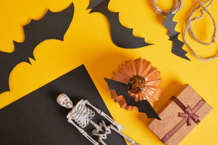 halloween decor and gift boxes on yellow background top view, skeletons, pumpkins and gifts creative halloweenの写真素材