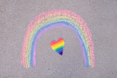 paper heart painted in rainbow colors of lgbt community and rainbow painted in chalk on asphaltの写真素材