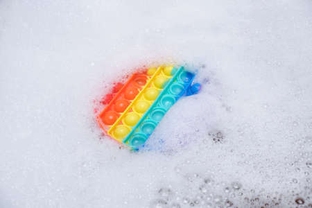 antistress toy with silicone bubbles pop in soapy foam in the bathroom copy spaceの写真素材