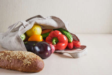 Eco friendly reusable mesh string knitted shopping bag with fruits and vegetables on the table, zero waste conceptの写真素材