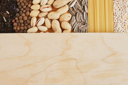 spices, tea, cereals, nuts, seeds and pasta texture, wood board for your text copy space mock up, grocery concept top viewの写真素材