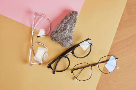 eye glasses on a concrete podium on a pink and beige background, trend composition, black stylish eye glasses, copy spaceの写真素材