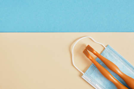 doll's legs lie on a blue face mask on a blue and beige background, beach vacation and tuzism during the coronavirus epidemic concept, protection from the virusの写真素材