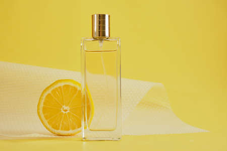 citrus scent, perfume with lemon scent concept, lemon slice and bottle of perfume on yellow background copy spaceの写真素材