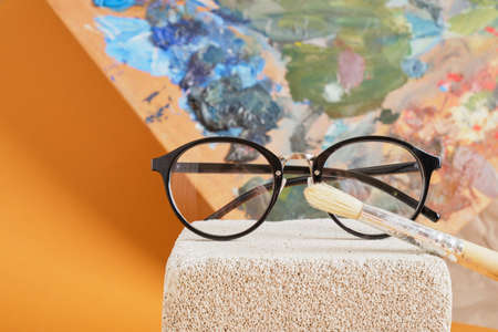 eye glasses on concrete block and palette brown background, artist workshop concept copy spaceの写真素材