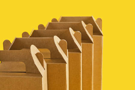 several cardboard boxes on a yellow background, boxes for a gift or product delivery without a blank...