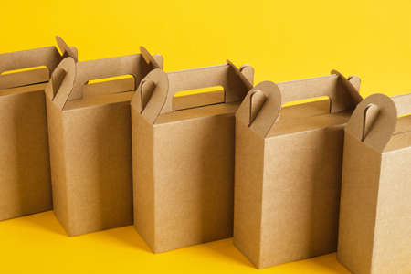 several cardboard boxes on a yellow background, boxes for a gift or product delivery without a logo, blank packaging for your design copy spaceの写真素材