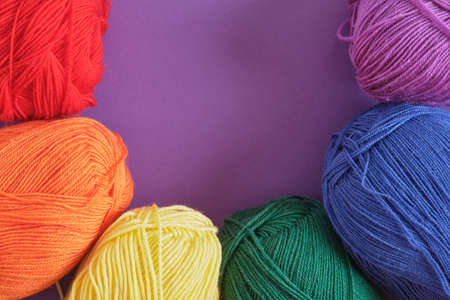 skeins of lgbt flag colors on purple background copy space knitting lgbt symbols concept
