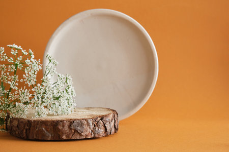 round wooden podium made of saw cut wood and a flower on a brown background, round ceramic podium for the backgroundの写真素材