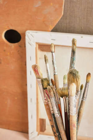 brushes, canvases and palette against the wall, artist's workshop conceptの写真素材