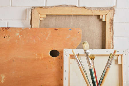 brushes, canvases and palette against the wall, artist's workshop concept