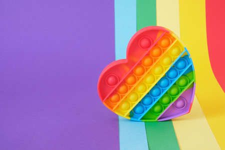 heart shaped colorful antistress sensory toy fidget push pop it on rainbow background top view copy spaceの写真素材