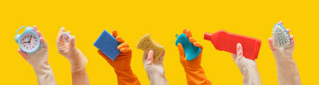 general cleaning and cleaning service concept, hands in rubber gloves hold cleaning tools yellow background bannerの写真素材