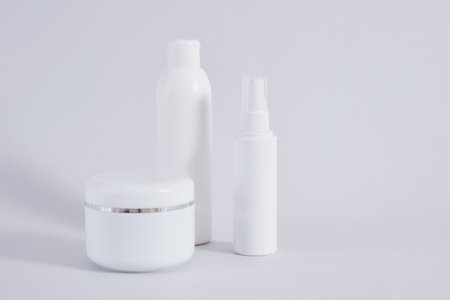 Composition of different cosmetic bottles mock-up on gray background, cream jar, bottles for oil or gel and sparay bottle for perfumeの写真素材