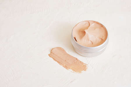 open jar with pink clay on a light textured background, smear of clayの写真素材