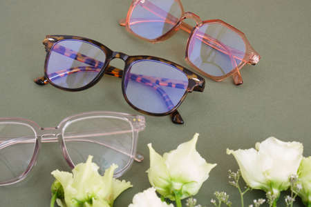 trendy eye glasses and roses on a green background