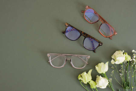 trendy eye glasses and roses on a green background