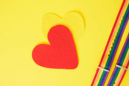 felt hearts and two bracelets with lgbt colors on yellow background copy space top view close up, pride conceptの写真素材