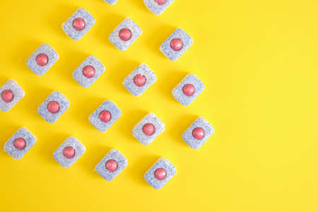 pattern dishwasher tablets on a yellow background top view