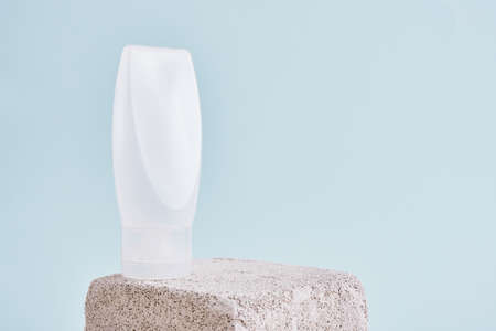 Blank white plastic tube with flip top cap on square concrete podium. Packaging of skincare product. Cosmetic beauty product branding mock up.の写真素材