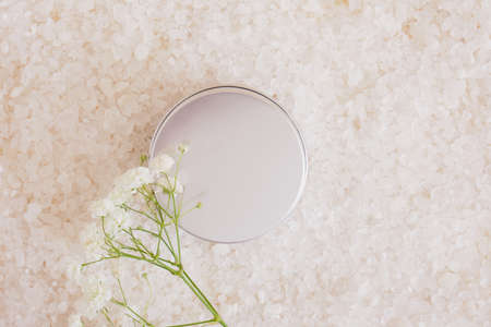Sea bath salt, flower and aluminum jar on beige background. mock upの写真素材
