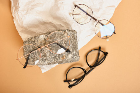 two stylish glasses on a stone on a background of crumpled white paper, trendy still life, accessories for vision correction beige backgroundの写真素材